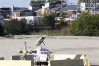 A natural gas well is juxtaposed with apartment buildings a few hundred feet away in Arlington, Texas, on Monday, Oct. 25, 2021. The site, known as "AC-360," is operated by TEP Barnett, a subsidiary of French energy giant Total Energies. It is one of Total's 33 well sites in Arlington that contain 163 wells. The company has proposed adding three new wells at this site. Some residents of the predominately Hispanic and Black neighborhood, as well as parents and staff at a daycare near the site, oppose the plan, citing health concerns. (AP Photo/Martha Irvine)