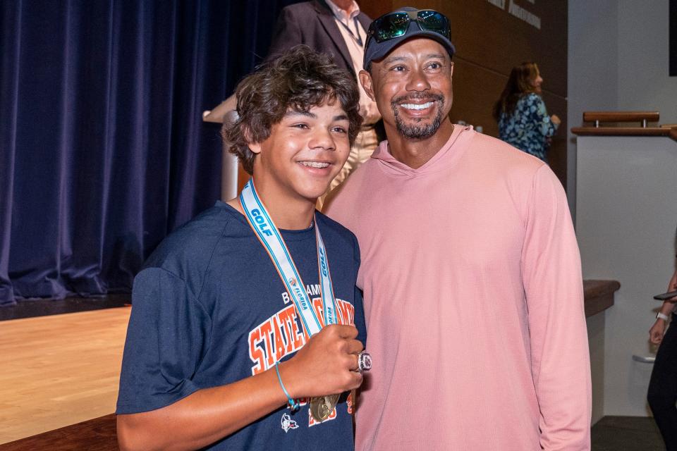 Golfer Charlie Woods shows off his new ring with his father, Tiger Woods, during a ceremony to celebrate The Benjamin School boys golf team 2023 state championship on March 26, 2024 in Palm Beach Gardens, Florida.