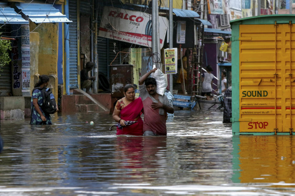 People wade through a flooded street in Chennai, India, Wednesday, Nov.25, 2020. India’s southern state of Tamil Nadu is bracing for Cyclone Nivar that is expected to make landfall on Wednesday. The state authorities have issued an alert and asked people living in low-lying and flood-prone areas to move to safer places. (AP Photo/R. Parthibhan)