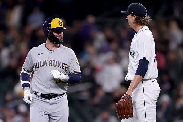 Jesse Winker of the Milwaukee Brewers talks with Logan Gilbert of the Seattle Mariners.