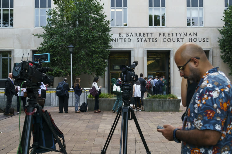 Members of the media are seen outside the E. Barrett Prettyman United States District Court House