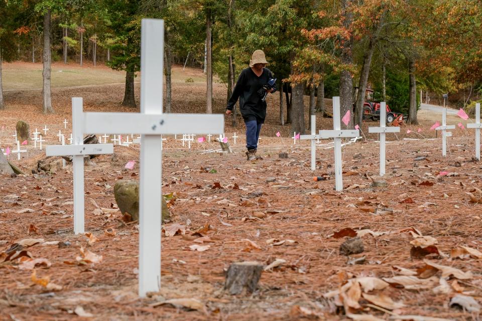 Pat Kemp, president of the Prewitt Slave Cemetery Association, sets up crosses to mark graves of slaves in the cemetery which lies alongside the historic Byler Road in Tuscaloosa County Oct. 26, 2023. The Byler Road was the first road authorized by the Alabama State Legislature.
