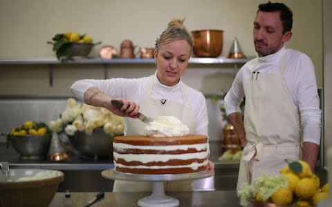 Claire Ptak and head baker Izaak Adams put finishing touches to the cake  - Credit: HANNAH MCKAY/REUTERS