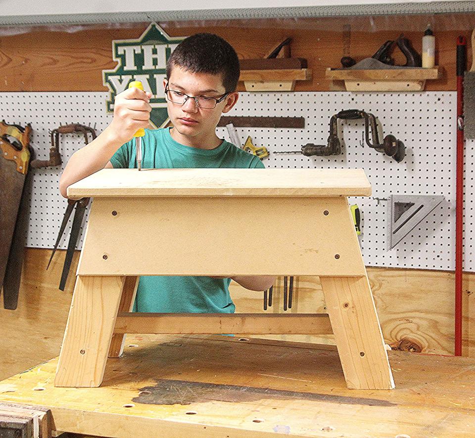 Quentin Craft tightens some screws on a wooden bench project in the woodshop at Pathfinder Farms. TONY ORENDER/For ASHLAND TIMES-GAZETTE