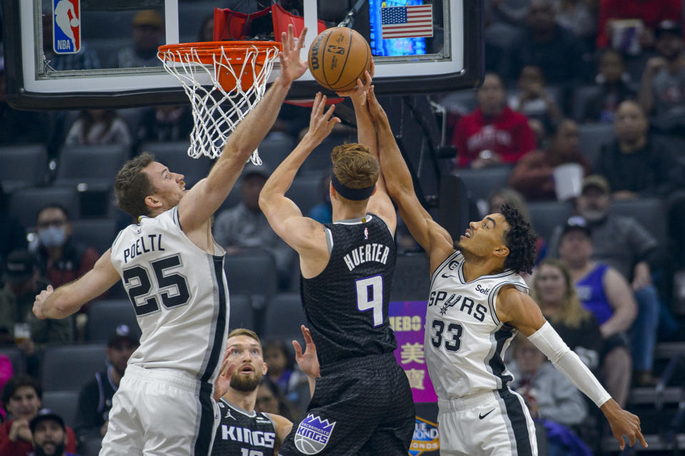 Sacramento Kings guard Kevin Huerter (9) shoots over San Antonio Spurs center Jakob Poeltl (25) and Spurs guard Tre Jones (33) during the first quarter of an NBA basketball game in Sacramento, Calif., Thursday, Nov. 17, 2022. (AP Photo/Randall Benton)