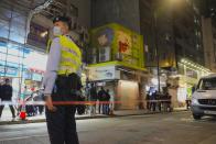 FILE - A police officer stands guard outside a pet store that was closed after some pet hamsters were, authorities said, tested positive for the coronavirus, in Hong Kong on Jan. 18, 2022. The city is culling small animals including hamsters and chinchillas and halting their import and sales after several hamsters in the pet shop tested positive for the coronavirus.(AP Photo/Kin Cheung, File)