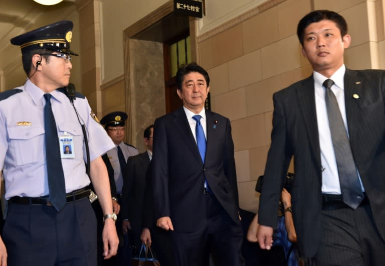 Japanese Prime Minister Shinzo Abe (C) enters a parliamentary committee room for discussion on his controversial security bills at the National Diet in Tokyo on July 15, 2015