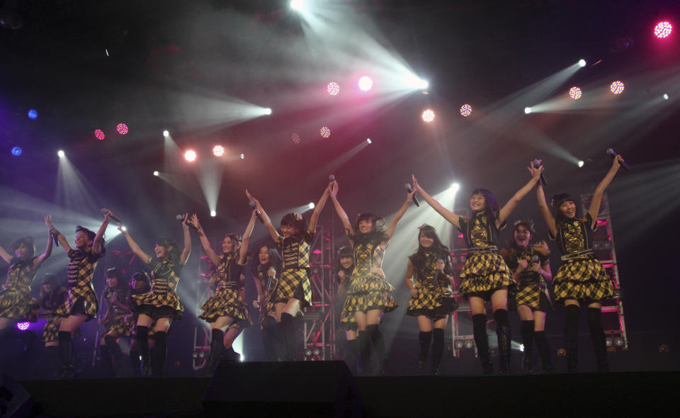 FILE - In this Feb. 25, 2012 file photo, members of JKT48, a sister group of Japanese idol group AKB48 perform during their joint concert in Jakarta, Indonesia. AKB48 is not exactly a band. It's an army of girls-next-door, ranked by its fans, and after taking Japan by storm it's getting ready to go global. JKT48, made up of Indonesian girls and young women, follows exactly the same routine as AKB. (AP Photo/Dita Alangkara, FIle)