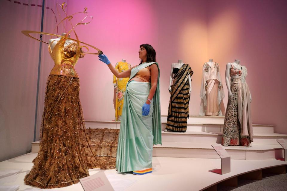 Design Museum's Head of Curatorial Priya Khanchandani looks at the sari by Sabyasachi saree with a bustier by Schiaparelli, worn by Indian businesswoman and socialite Natasha Poonawalla at the 2022 Met Gala (AFP via Getty Images)