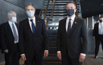 Icelandic Foreign Minister Gudlaugur Thor Thordarson, right, greets US Secretary of State Antony Blinken centre, left, as he arrives for meetings at the Harpa Concert Hall in Reykjavik, Iceland, Tuesday, May 18, 2021. Blinken is touting the Biden administration's abrupt shift in its predecessor's climate policies as he visits Iceland for talks with senior officials from the world's Arctic nations. (Saul Loeb/Pool Photo via AP)