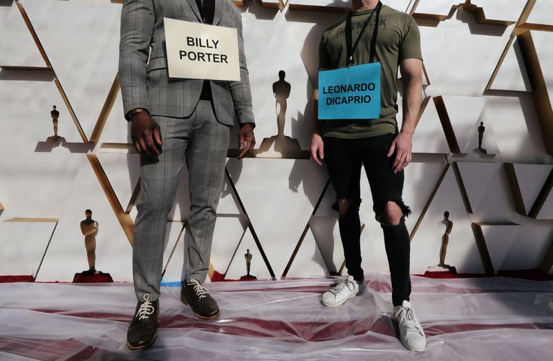 Stand-ins pose with signs reading Billy Porter and Leonardo DiCaprio as Oscars as preparations continue for the 92nd Academy Awards in Hollywood