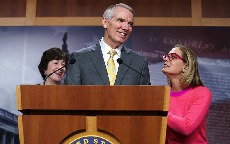 Sen. Kyrsten Sinema (D-Ariz.) interrupts Sen. Rob Portman (R-Ohio) during a press conference