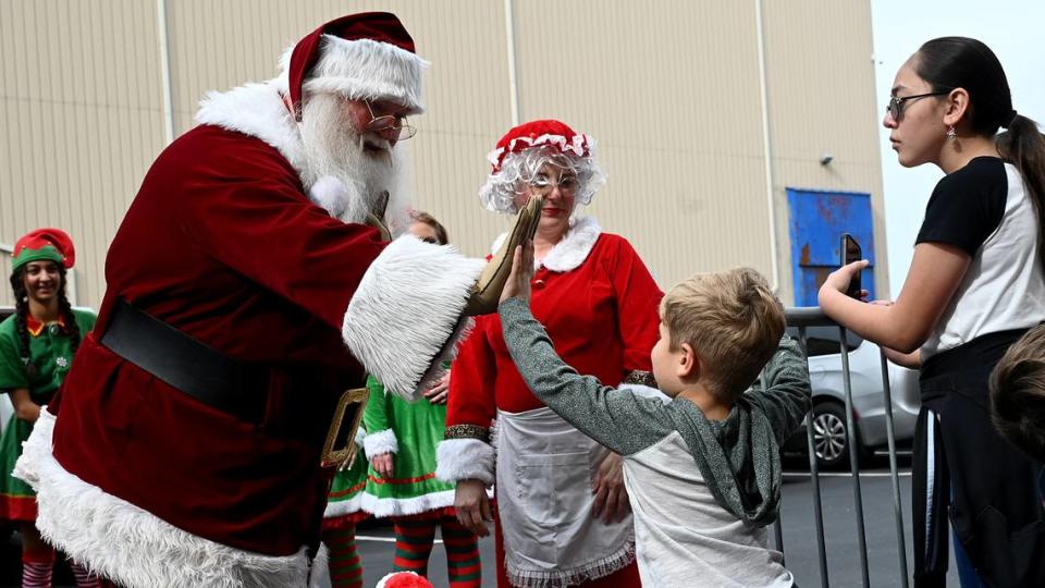 Santa gets a high-five from a young admirer at the 38th annual Flight to the North Pole program for children with disabilities and terminal illnesses at Feld Entertainment in Palmetto.