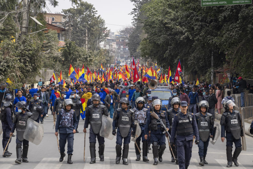 Police escort supporters of Rastriya Prajatantra Party, or national democratic party, during a pro-monarchy protest in Kathmandu, Nepal, Feb. 21, 2024. Nepal’s once unpopular monarchy — abolished after centuries of rule over the Himalayan nation — is hoping to regain some of its lost glory. Royalist groups and supporters of former King Gyanendra have been holding rallies to demand the restoration of the monarchy and the nation’s former status as a Hindu state. (AP Photo/Niranjan Shrestha)