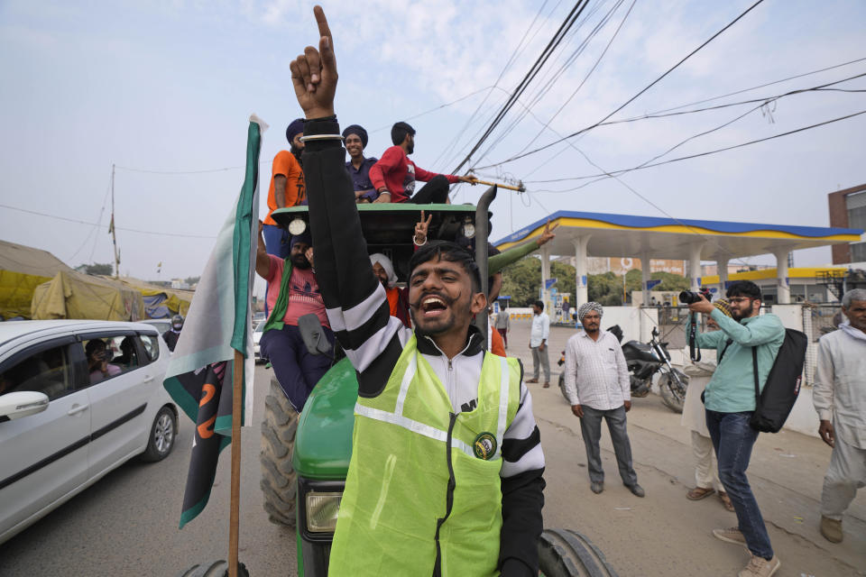 Farmers celebrate news of the repeal of farm laws they were protesting against, in Singhu, on the outskirts of New Delhi, India, Friday, Nov. 19, 2021. Prime Minister Narendra Modi has said his government will withdraw the controversial farm laws that were met with year-long demonstrations from tens of thousands of farmers who said the laws will shatter their livelihoods. The drawn-out demonstrations have posed one of the biggest political challenges to Modi, who swept the polls for the second time in 2019. (AP Photo/Manish Swarup)