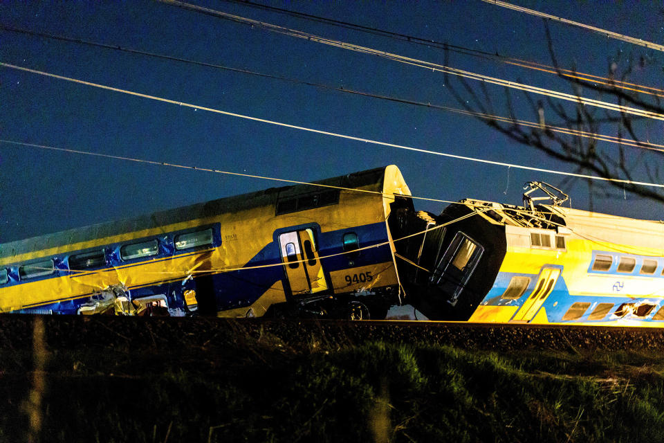 a yellow derailed train at night