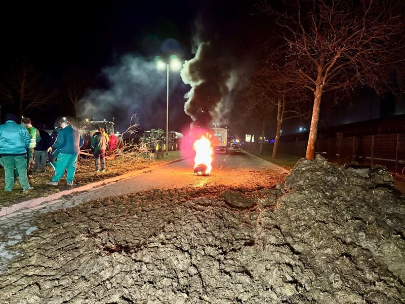 Farmers block a road near Magdeburg with manure and burning tyres. Thomas Schulz/dpa