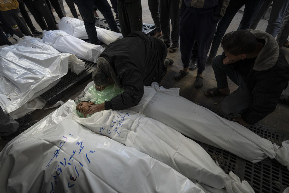 Members of the Abu Sinjar family mourn their relatives killed in the Israeli bombardment of the Gaza Strip outside a morgue in Rafah, southern Gaza, Friday, Jan. 5, 2024. (AP Photo/Fatima Shbair)