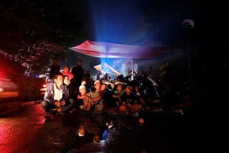 Villagers watch a film during a wedding party in Bogor, Indonesia, February 18, 2017. REUTERS/Beawiharta/Files