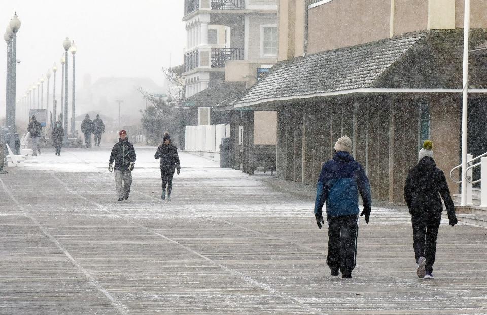 People walk the Boardwalk as light snow has been falling over Rehoboth Beach with little accumulation as the temperature hovers around 32 degrees at the beach on Sun., Jan. 31, 2021.