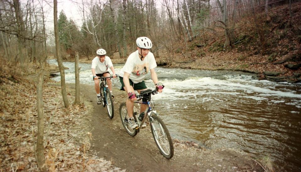 Cyclists ride a trail along Baird Creek.
