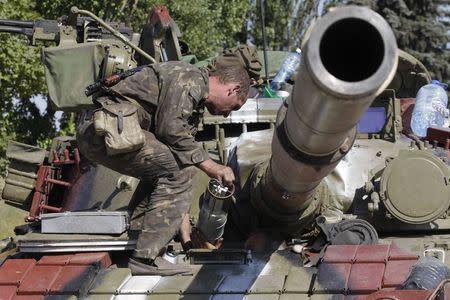 A Ukrainian serviceman loads a shell onto a tank at a checkpoint in the southern coastal town of Mariupol, September 5, 2014. REUTERS/Vasily Fedosenko