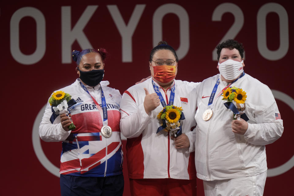 Gold medalist Li Wenwen of China, center, poses with silver medalist Emily Jade Campbell of Britain, left, and bronze medalist Sarah Elizabeth Robles of the United States, in the medals ceremony for the women's +87kg weightlifting at the 2020 Summer Olympics, Monday, Aug. 2, 2021, in Tokyo, Japan. (AP Photo/Luca Bruno)