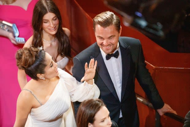 Camila Morrone and Leonardo DiCaprio at the 2020 <a href="https://parade.com/movies/oscars-2023-academy-awards" rel="nofollow noopener" target="_blank" data-ylk="slk:Oscars;elm:context_link;itc:0;sec:content-canvas" class="link ">Oscars</a> (seen here with Salma Hayek)<p>Arturo Holmes/Getty Images</p>