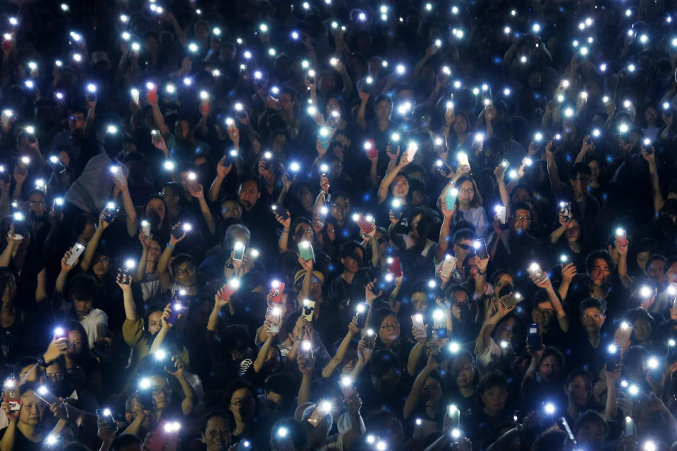 Attendees hold up their lit mobile phones during a rally by mothers in Hong Kong on Friday, July 5, 2019. Hong Kong's societal divide showed no sign of closing Friday as students rebuffed an offer from city leader Carrie Lam to meet and a few thousand mothers rallied in support of young protesters who left a trail of destruction in the legislature's building at the start of the week. (AP Photo/Kin Cheung)