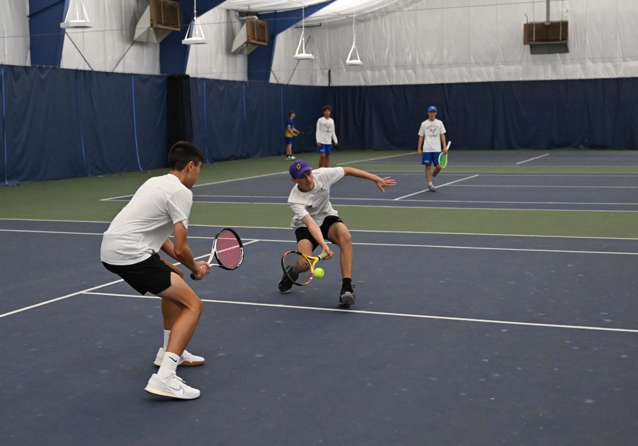 Ethan Remy watches as Dylan Catanese bends low to return a shot in Saturday's Lexington Invitational