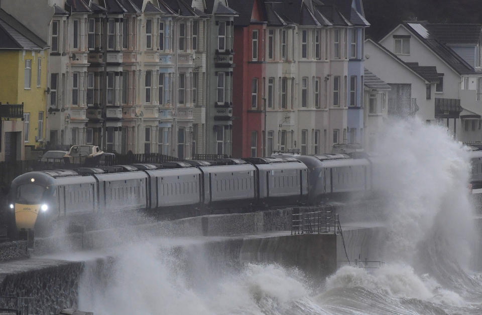 Large waves hit the sea wall with Storm Brendan bringing high winds and heavy rain, as a train passes through Dawlish, southwest Britain, January 14, 2020. REUTERS/Toby Melville