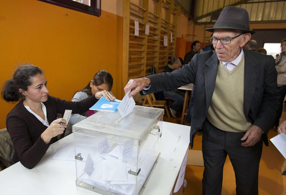 Galician citizen, right, votes in Vigo, northwestern Spain, Sunday Oct. 21, 2012. Almost 4.5 million people will go to the polls Sunday in regional elections in Spain's turbulent Basque region and in Galicia. (AP Photo/Lalo R. Villar)