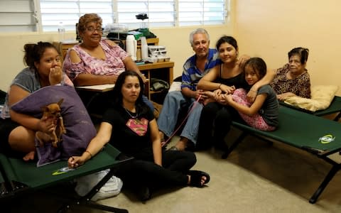 Cruz poses for a picture with his family as they rest in a school used as a shelter before the arrival of the Hurricane Maria in Guayama - Credit: CARLOS GARCIA RAWLINS/Reuters