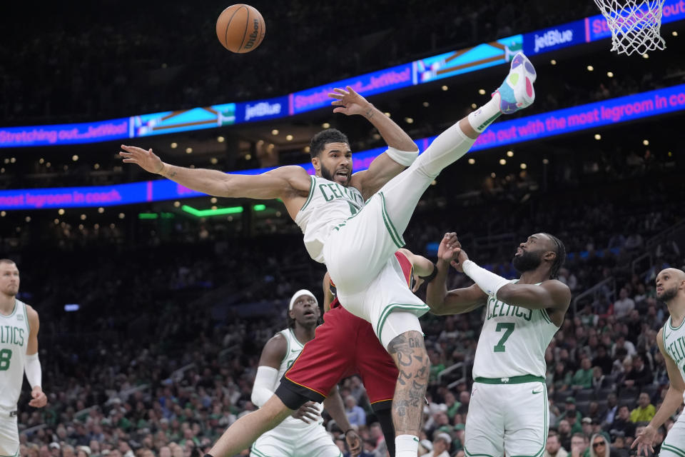 Miami Heat forward Caleb Martin, behind center, fouls Boston Celtics forward Jayson Tatum, front center, in front of Celtics guard Jaylen Brown (7) in the second half of Game 1 of an NBA basketball first-round playoff series, Sunday, April 21, 2024, in Boston. (AP Photo/Steven Senne)