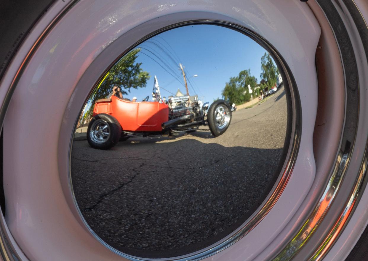 A 1920s Ford T-Bucket is reflected in the hubcap of a 62 Plymouth Sport Fury at Chloe's Diner's weekly Cruise In in downtown Massillon.