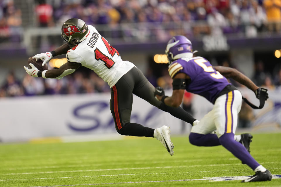 Tampa Bay Buccaneers wide receiver Chris Godwin (14) catches a pass in front of Minnesota Vikings defender Mekhi Blackmon (5) during the second half of an NFL football game, Sunday, Sept. 10, 2023, in Minneapolis. The Buccaneers won 20-17. (AP Photo/Abbie Parr)