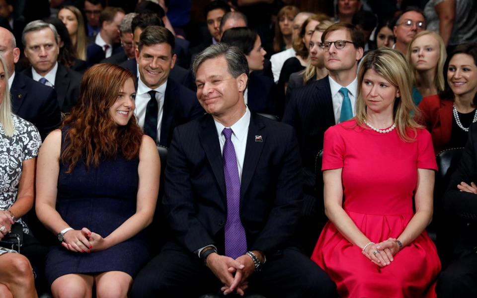 Christopher Wray is seated with his daughter Caroline and wife Helen  - Credit: Reuters