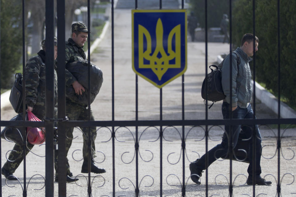 Ukrainian air force officers walk with their belongings at the Belbek airbase, outside Sevastopol, Crimea, on Thursday, March 20, 2014. With thousands of Ukrainian soldiers and sailors trapped on military bases, surrounded by heavily armed Russian forces and pro-Russia militia, the Kiev government said it was drawing up plans to evacuate its outnumbered troops from Crimea back to the mainland and would seek U.N. support to turn the peninsula into a demilitarized zone. (AP Photo/Ivan Sekretarev)