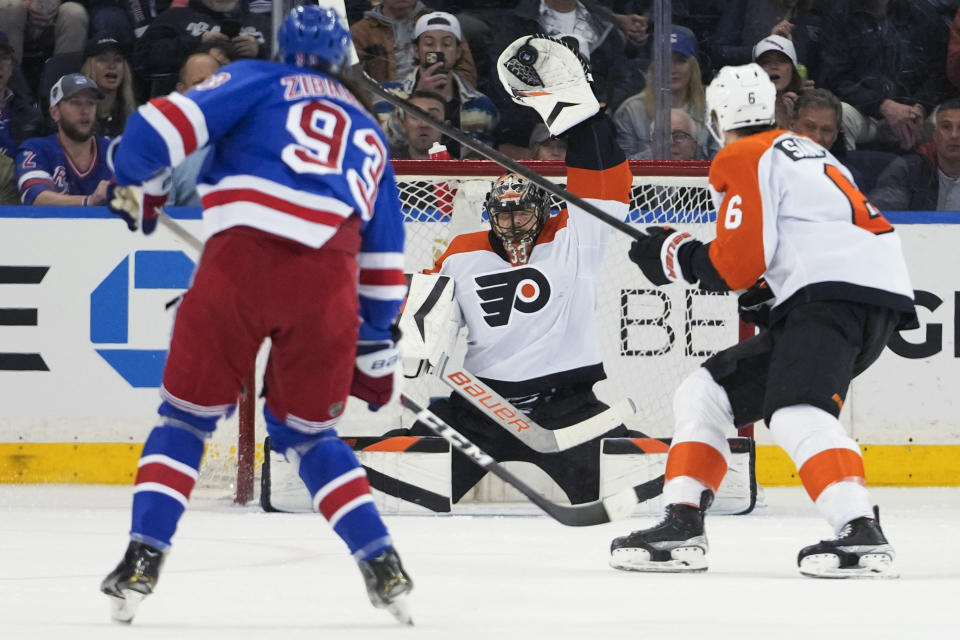 Philadelphia Flyers goaltender Samuel Ersson (33) makes a save against New York Rangers center Mika Zibanejad (93) during the first period of an NHL hockey game Thursday, April 11, 2024, at Madison Square Garden in New York. (AP Photo/Mary Altaffer)