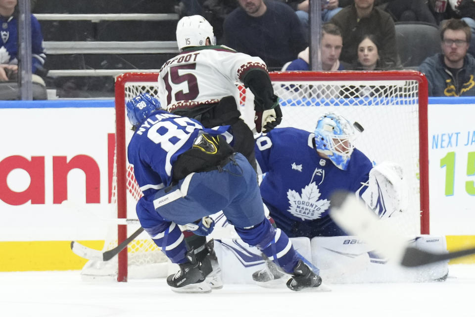 Arizona Coyotes' Alex Kerfoot (15) scores against Toronto Maple Leafs goaltender Joseph Woll, right, during second-period NHL hockey game action in Toronto, Thursday, Feb. 29, 2024. (Chris Young/The Canadian Press via AP)