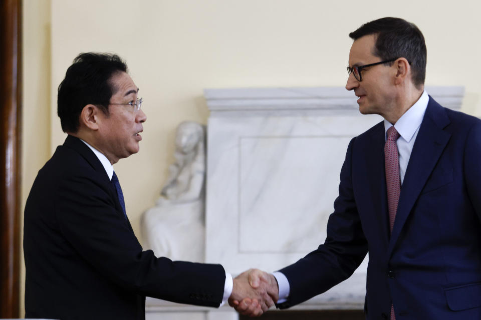 Polish Prime Minister Mateusz Morawiecki, right, and Japanese Prime Minister Fumio Kishida, left, shake hands after a press conference in Warsaw, Poland, Wednesday, March 22, 2023. (AP Photo/Michal Dyjuk)