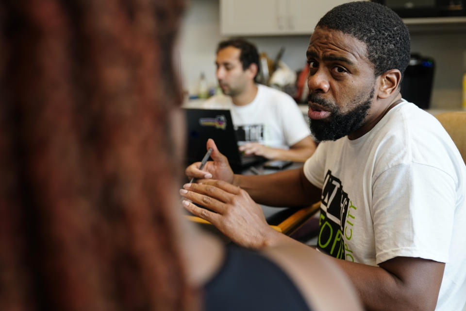 Curtis Duncan, right, trains a new volunteer at one of the "Stop Cop City" movement headquarters, Thursday, July 20, 2023, in Atlanta. Activists with the "Stop Cop City" Vote Coalition are trying to get the signatures of more than 70,000 Atlanta residents by Aug. 14 to force a referendum allowing voters to decide the fate of a proposed police and firefighter training center. (AP Photo/Brynn Anderson)