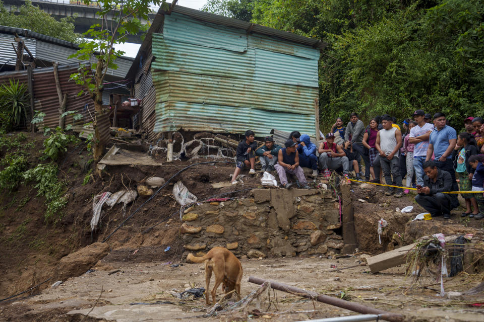 Neighbors watch firefighters search for survivors where homes were swept away overnight by a swollen Naranjo River after heavy rain in the "Dios es fiel," or "God is Loyal" shanty on the outskirts of Guatemala City, Monday, Sept. 25, 2023. (AP Photo/Moises Castillo)