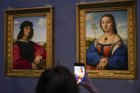 Un periodista toma fotos de los retratos de Angelo y Maddalena Doni del siglo XV de Raffaello Sanzio da Urbino durante un recorrido de prensa por la Galería Uffizi en su reapertura después de tres meses de cierre por el brote de coronavirus el 3 de junio de 2020 (Foto AP/Andrew Medichini)