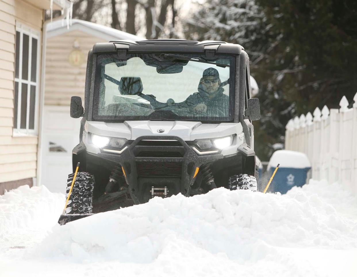 Norton councilman Doug DeHarpart plows the driveway of a Norton resident on Tuesday. 