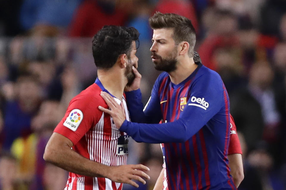 Barcelona's Gerald Pique, right, talks to Atletico forward Diego Costa who was sent off with a red card for insulting referee Jesus Gil Manzano during a Spanish La Liga soccer match between FC Barcelona and Atletico Madrid at the Camp Nou stadium in Barcelona, Spain, Saturday April 6, 2019. (AP Photo/Manu Fernandez)