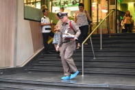 A member of the Thai Royal Police walk out of the Century Plaza mall Tuesday, Feb. 18, 2020 in Bangkok, Thailand. Gun violence has struck again at a shopping mall in Thailand, where a man in the nation's capital Bangkok shot dead one woman working in a beauty clinic and wounded another. (AP Photo)