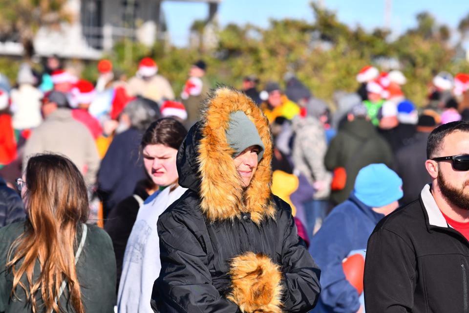 Spectators bundled up in winter clothing for Surfing Santas on Christmas Eve in Cocoa Beach.