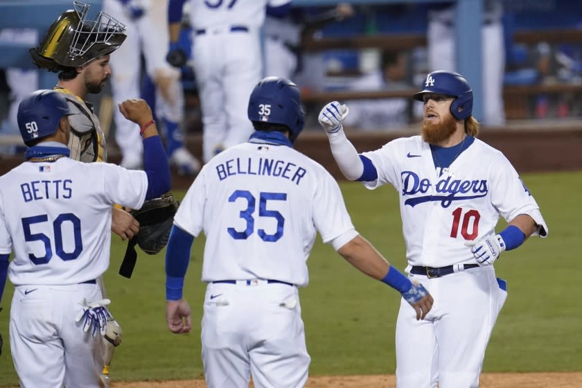 Los Angeles Dodgers' Justin Turner (10) celebrates his three-run home run with Cody Bellinger (35) and Mookie Betts (50) during the eighth inning of the team's baseball game against the San Diego Padres on Wednesday, Aug. 12, 2020, in Los Angeles. (AP Photo/Marcio Jose Sanchez)