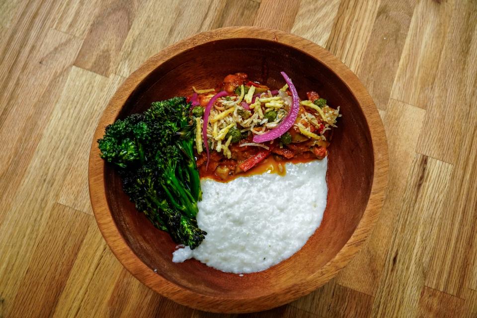 A shrimp moqueca, coconut rice grits and broccolini dish prepared by Digby Stridiron, chef and co-owner at Latha Restaurant & Bar, is displayed at the restaurant located within the Diaspora Collective in Phoenix on April 19, 2023.